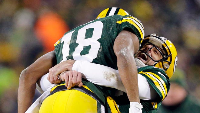 Green Bay Packers wide receiver Randall Cobb (18) celebrates with quarterback Aaron Rodgers (12) after scoring a touchdown on a hail mary in the 2nd quarter in the NFC Wild Card playoff football game at Lambeau Field.