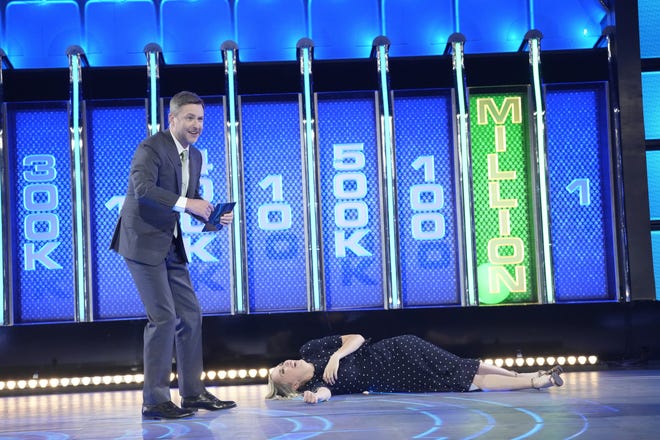 Christiana Trapani, co-owner of Door County Candle Co., falls to the ground next to host Chris Hardwick after the green ball falls into the $1 million slot, adding that amount to her winnings on the NBC-TV game show "The Wall." Christiana was a contestant with her husband, Nic, on the April 11, 2023, season premiere of the show.